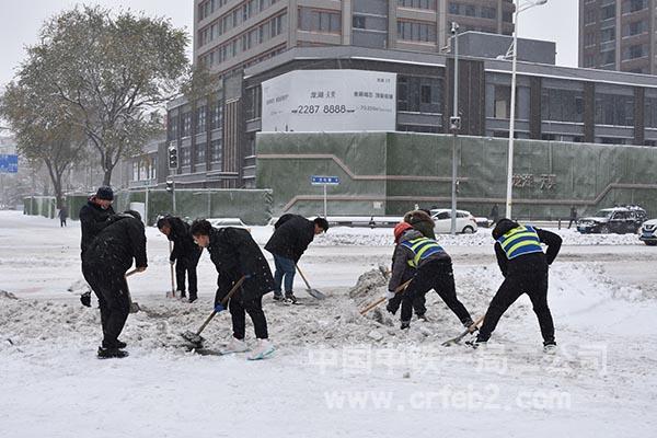 项目员工义务清扫十字路口积雪